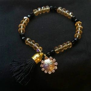 Gold toned pendent with black tassel